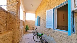 a bike parked next to a building with a window at هوستل أجبناخ إنشالي Hostel Agbenakh Inshaly in Siwa