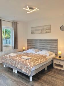 ein Schlafzimmer mit einem großen Bett und einem Deckenventilator in der Unterkunft Apartamenty Nexo in Neksø