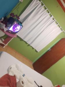 a room with a television and a roll of toilet paper at Mel Pousada in Macaé