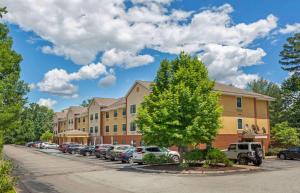 eine Reihe von Autos, die vor einem Gebäude geparkt sind in der Unterkunft Extended Stay America Suites - Nashua - Manchester in Nashua