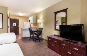 a hotel room with a bed and a flat screen tv at Extended Stay America Suites - Nashua - Manchester in Nashua