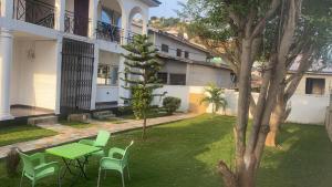 a green table and chairs in a yard next to a building at Charming 1-Bed Apartment in Accra in New Weija