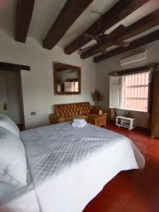 ein Schlafzimmer mit einem großen weißen Bett und einem Sofa in der Unterkunft EMMA HOTEL SAN DIEGO in Cartagena de Indias
