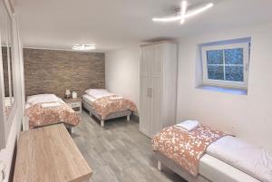 a bedroom with two beds and a table and a window at Apartamenty Nexo in Neksø
