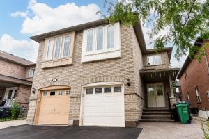 a brick house with two white garage doors at Luxury Home In Castlemore Brampton in Brampton