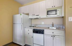 a kitchen with white cabinets and a white refrigerator at Extended Stay America Suites - Washington, DC - Chantilly - Airport in Chantilly