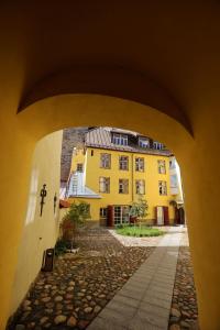 a view of a yellow building through an archway at Toompea Castle Apartment in Tallinn