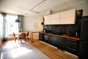 a kitchen with black cabinets and a table and a dining room at Toompea Castle Apartment in Tallinn
