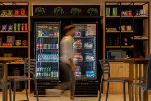 a person walking in front of a refrigerator at Sooz Hotel Collection in Sao Paulo