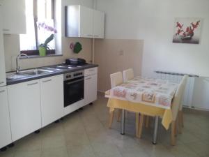 a kitchen with a table and a sink and a stove at Apartments Krt Mirko in Izola
