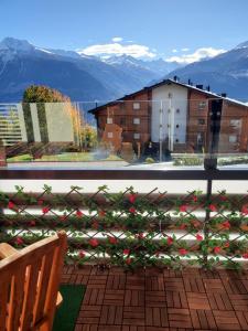 a balcony with a view of a building and mountains at Appartement l Magnifique vue l Proche Crans-Montana in Crans-Montana