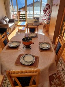 uma mesa com pratos e uma tigela em cima em Appartement l Magnifique vue l Proche Crans-Montana em Crans-Montana