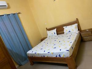 a bedroom with a bed with a blue curtain at Le Poulagou in Saint-Louis