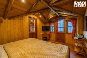 une chambre avec un lit dans une pièce aux murs en bois dans l'établissement StayVista at Rosemary Cottage 2BR Villa in Manali with Lawn, à Manali