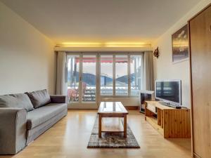 a living room with a couch and a television at Appartement l Magnifique vue l Proche Crans-Montana in Crans-Montana