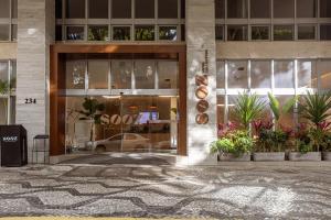 ein Geschäft vor einem Gebäude mit Pflanzen davor in der Unterkunft Sooz Hotel Collection in São Paulo