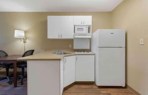 a kitchen with white cabinets and a white refrigerator at Extended Stay America Suites - Washington, DC - Chantilly - Dulles South in Chantilly