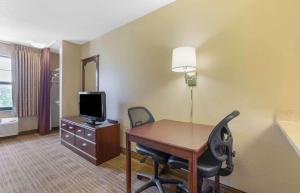 a hotel room with a desk and a tv and a room at Extended Stay America Suites - Washington, DC - Chantilly - Dulles South in Chantilly
