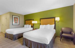 a hotel room with two beds and a chair at Extended Stay America Suites - Washington, DC - Chantilly - Dulles South in Chantilly