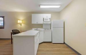 a kitchen with white cabinets and a white refrigerator at Extended Stay America Suites - Washington, DC - Chantilly - Dulles South in Chantilly