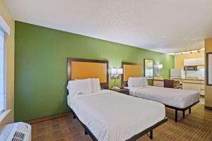 two beds in a room with a green wall at Extended Stay America Suites - Washington, DC - Reston in Herndon