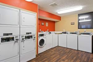 a laundry room with white washing machines and orange walls at Extended Stay America Suites - Washington, DC - Reston in Herndon