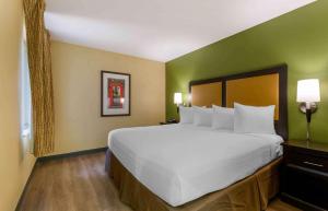 a bedroom with a large white bed with green walls at Extended Stay America Suites - Washington, DC - Fairfax in Fairfax