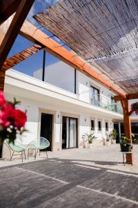 a building with two chairs in front of it at Jasmine Hotel in São Pedro de Alva