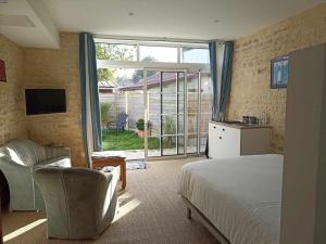 a bedroom with a bed and a sliding glass door at Villa kahlo Omaha Beach in Colleville-sur-Mer