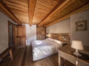a bedroom with a bed and a wooden ceiling at La Mizoùn de Marguerito - Appartamento Ginestra in Acceglio