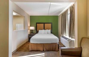 een slaapkamer met een bed en een groene muur bij Extended Stay America Suites - Des Moines - West Des Moines in Clive