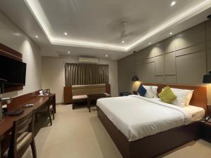 una camera d'albergo con un letto grande e una scrivania di Five Elements a Visakhapatnam