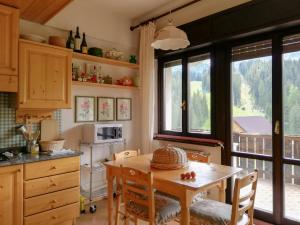 a kitchen with a table with chairs and a window at Casa Sappada Appartamento in Sappada