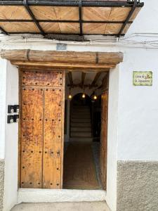 una entrada a un edificio con puerta de madera en Alojamiento Picual, en Iznatoraf