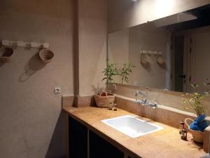 bagno con lavandino e grande specchio di Riad Hostel JAD ZIAD a Marrakech