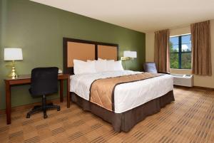 a hotel room with a bed and a desk and a chair at Extended Stay America Select Suites - Chicago - O'Hare in Rosemont