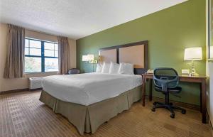 Hanover Park的住宿－Extended Stay America Select Suites - Chicago - Hanover Park，酒店客房配有一张床、一张桌子和一把椅子。