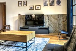 ein Wohnzimmer mit einem Couchtisch und einem TV in der Unterkunft Andrea 7 by SMR Rauris Apartments - inc Spa and National Summercard - near Gondola in Rauris