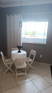 een tafel en stoelen in een kamer met een raam bij Apartamento a 1200m da praia 2 quartos in Vila Velha