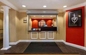 um átrio com uma parede vermelha e um espelho em Extended Stay America Suites - Chicago - O'Hare - Allstate Arena em Des Plaines