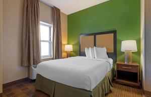 1 dormitorio con 1 cama grande y pared verde en Extended Stay America Suites - Chicago - O'Hare - Allstate Arena, en Des Plaines
