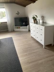 een woonkamer met een televisie en een witte dressoir bij Apartment Valerie - Villa Mühlei Alterbachstr 9 in Anif