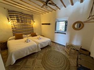 a bedroom with two beds in a room with a window at Alojamiento Manzanilla in Iznatoraf