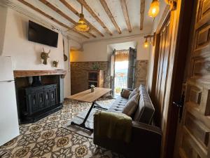 - un salon avec un canapé et une cheminée dans l'établissement Alojamiento Manzanilla, à Iznatoraf