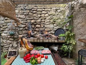 une table avec des fruits et des légumes devant un mur de pierre dans l'établissement Alojamiento Manzanilla, à Iznatoraf