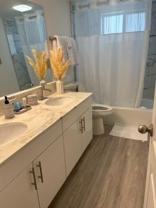 a bathroom with two sinks and a toilet and a mirror at ROYAL COLONIAL in Boca Raton