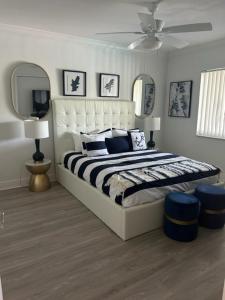 een slaapkamer met een groot bed en 2 spiegels bij ROYAL COLONIAL in Boca Raton