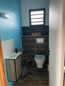 ein Bad mit einem WC, einem Waschbecken und einem Fenster in der Unterkunft Ti-Kaz Gwada Le Gosier in Le Gosier