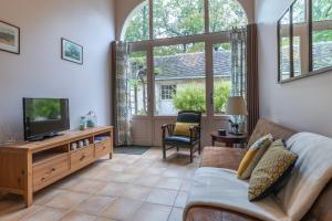 a living room with a couch and a tv at Gîtes de la Bigauderie in Montlouis-sur-Loire