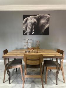 a dining room table with an elephant painting on the wall at Tamaniroom- a private 1bed in Tamale